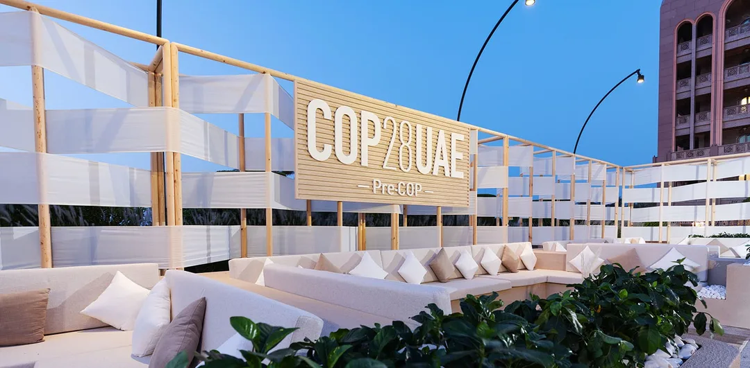 Evolution Furniture outdoor lounge with neutral sofas and natural tables at PRE-COP28, Emirates Palace.